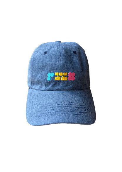 Blue denim cap with colorful embroidered design on a white background